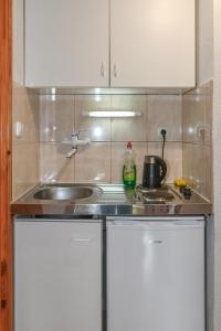a small kitchen with a sink and a stove at Klassz Apartmanház in Balatonfüred