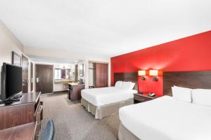 a hotel room with two beds and a flat screen tv at River's Edge Convention Center in Columbus