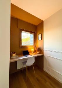 a desk with a laptop on it in a room with a window at FLOK horizon in Malbuisson