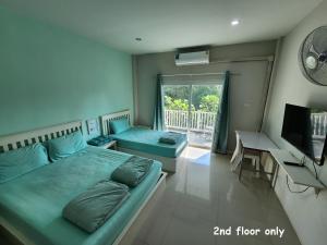 a bedroom with a bed and a desk and a television at Vanilla Ville Resort in Khlong Thom