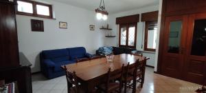 a living room with a table and a blue couch at Casa GALLI Como in Colverde