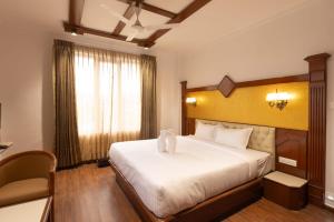 a bedroom with a bed with a teddy bear on it at Welbeck by The Beehives in Ooty +6 photos