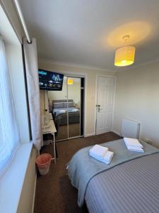 a bedroom with a bed with two towels on it at Comfortable double room with own bathroom in Inshes