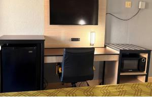 a room with a desk with a chair and a microwave at Milan inn & Suites in Milan