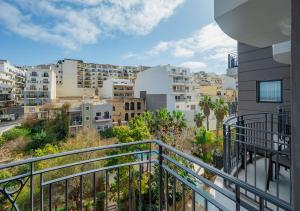 an apartment balcony with a view of a city at Maritim Antonine Hotel & Spa in Mellieħa