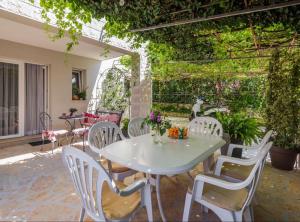a white table and chairs on a patio at Apartment Oaza in Supetar