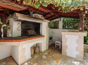 a outdoor kitchen with a pizza oven in a patio at Apartment Oaza in Supetar