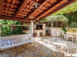 an outdoor patio with a bench and a fireplace at Apartment Oaza in Supetar +19 photos