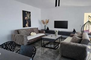 a living room with couches and a flat screen tv at Apartments Merin in Utjeha