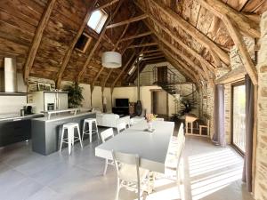 a kitchen and dining room with a table and chairs at LA PERLE DE LA VALLÉE in Montézic