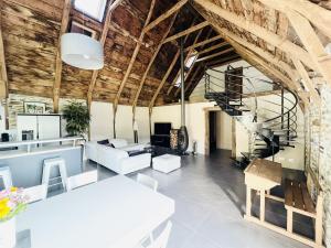 an open living room with wooden ceilings and a spiral staircase at LA PERLE DE LA VALLÉE in Montézic