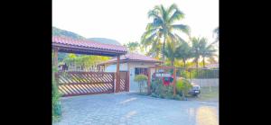 a house with a gate and a fence at Flat Duplex Premium - Maresias - 150m da Praia Piscina, Wi-Fi e Garagem in São Sebastião