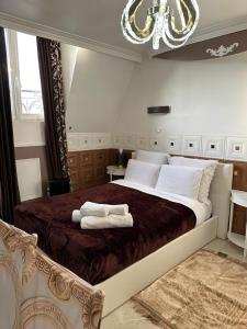 a bedroom with a large bed with two towels on it at Évasion à 10 Minutes de Paris Logements Privés in Deuil-la-Barre