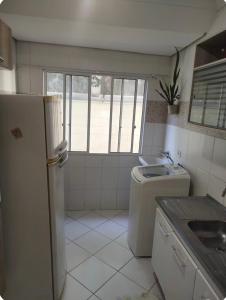 a small kitchen with a refrigerator and a sink at Casa aconchego in São Carlos