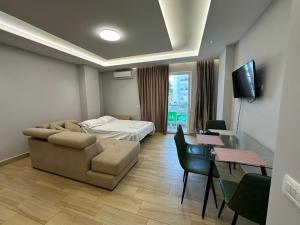 a room with a couch and a bed and a table at Sevians Apartments in Golem