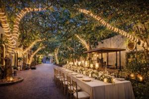 a long table with white tables and chairs under trees at HELLO VILLA & SPA in Hue +63 photos