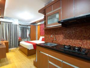 a bedroom with a bed and a kitchen with a sink at RedDoorz Apartment at Bogor Valley in Bogor +29 photos
