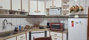 a kitchen with white cabinets and a white refrigerator at Casa Térrea em Correntina in Correntina +8 photos