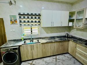 a kitchen with a sink and a washing machine at Polo Apartments Lekki in Lekki