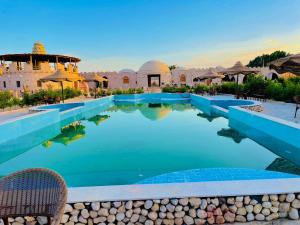 a pool at a resort in the desert at Adrartaziry in Siwa
