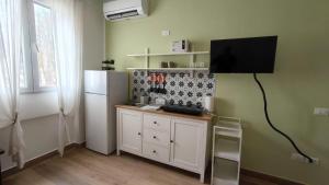 a kitchen with a refrigerator and a tv on the wall at Casa Noa in Crema