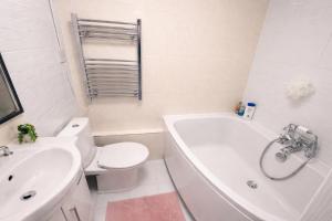 a bathroom with a toilet and a tub and a sink at Cosy Double Room in Shared Flat in Sutton