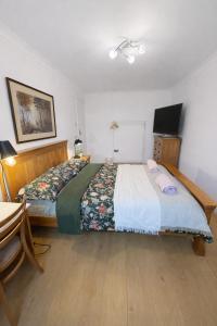 a bedroom with a large bed and a television at Cosy Double Room in Shared Flat in Sutton +1 photo