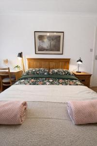 a bedroom with a large bed and a table at Cosy Double Room in Shared Flat in Sutton