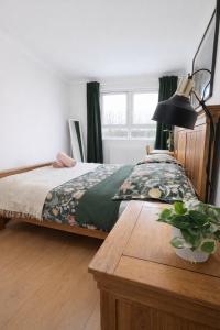 a bedroom with a bed with a table and a lamp at Cosy Double Room in Shared Flat in Sutton