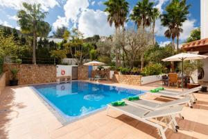 a swimming pool with chairs and umbrellas at Villa Blanca Santa Eulalia in Santa Eularia des Riu