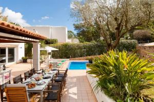 a patio with a table and chairs next to a pool at Villa Blanca Santa Eulalia in Santa Eularia des Riu