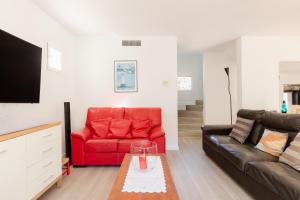 a living room with a red couch and a table at Villa Blanca Santa Eulalia in Santa Eularia des Riu