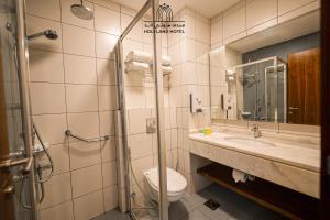 a bathroom with a toilet and a sink and a shower at Holyland Hotel Amman in Amman +28 photos