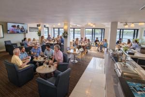 a group of people sitting at tables in a restaurant at The Dolby Hotel Liverpool - Free city centre parking in Liverpool