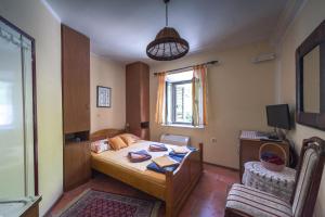 1 dormitorio con 1 cama, 1 silla y 1 ventana en Apartments Villa Ferri, en Kotor