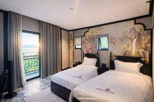 a hotel room with two beds and a balcony at Dragon King Hotel Nghệ An in Cửa Lô