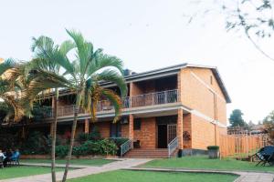a building with a palm tree in front of it at Kampala Kolping Hotel in Kampala