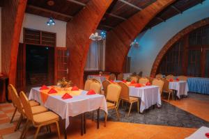 a banquet hall with tables and chairs with red napkins at Kampala Kolping Hotel in Kampala