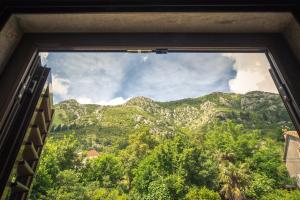 a window with a view of a mountain at Apartments Villa Ferri in Kotor