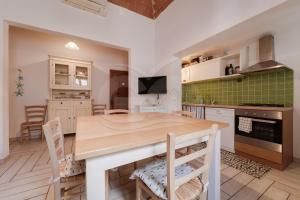 a kitchen and dining room with a wooden table and chairs at Appartamento Zoe - Goelba in Marina di Campo