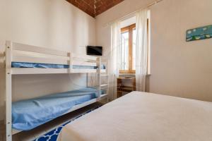 a bedroom with two bunk beds and a television at Appartamento Zoe - Goelba in Marina di Campo
