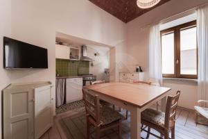 a kitchen with a table and chairs and a television at Appartamento Zoe - Goelba in Marina di Campo +12 photos