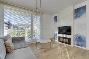 a living room with a couch and a tv at GRANO FLATS Sobieszewo - Villa Neptun in Sobieszewo