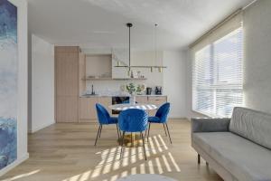 a living room with a table and blue chairs at GRANO FLATS Sobieszewo - Villa Neptun in Sobieszewo