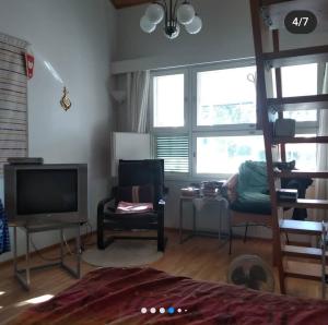 a bedroom with a bed and a tv and chairs at Дом на берегу озера Саймаа in Ruokolahti