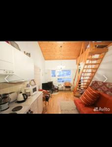 a kitchen with a staircase and a living room at Дом на берегу озера Саймаа in Ruokolahti