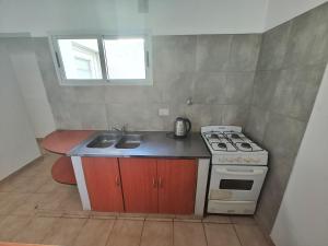 a small kitchen with a stove and a sink at Depto guemez1 in General Roca