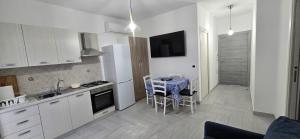 a kitchen with a table and a kitchen with white cabinets at La Casetta Nuova struttura in Palinuro