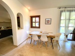a dining room with a table and white chairs at The Amathountas Residence in Pyrgos +1 photo