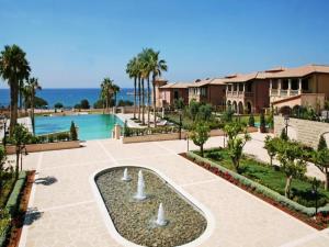 a resort with a swimming pool and palm trees at The Amathountas Residence in Pyrgos